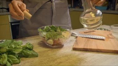 Kadın mutfakta salata pişiriyor.