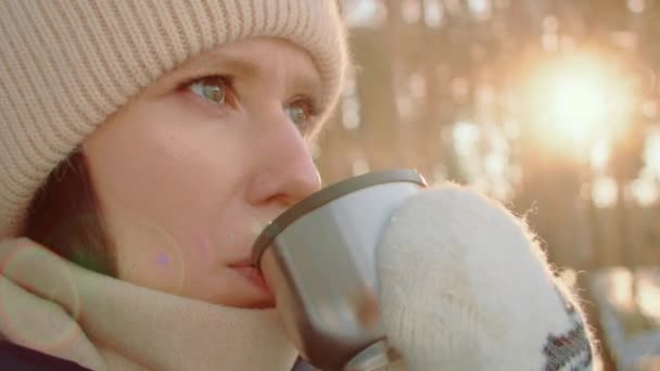 Femme voyageur tenant une tasse de thé, marchant dans la forêt gelée d'hiver enneigée. — Video