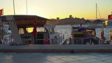 Bodrum limanında rıhtımlı tekneleri ve yatları olan yürüyen insanlarla yürüme.