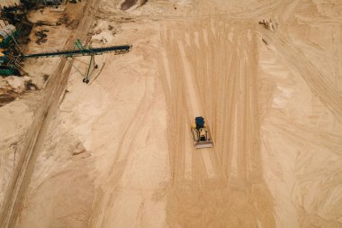 Buldozer machinery work in in opencast sand quarry. Aerial view of mining machinery. Mining industry