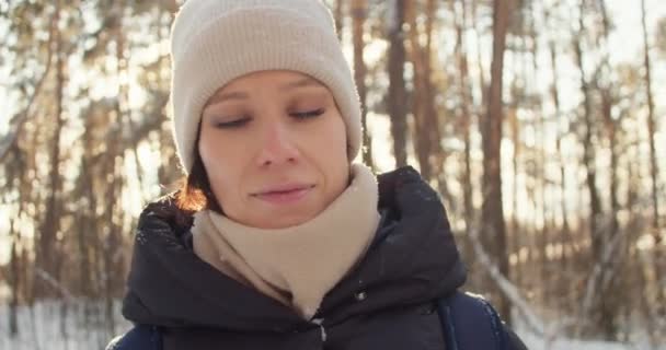 즐거운 여자가 겨울 숲에서 햇빛을 받으며 노는 모습 — 비디오