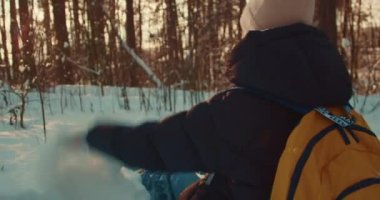 Karlı ormanda bir kadın ve bir avuç kar..