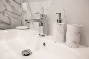 Banyoya mermer döşemeli beyaz lavaboyu kapat.