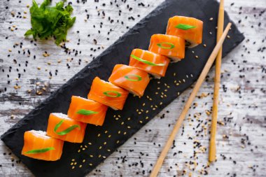 Açık somon balığı Philledelphia siyah masa beyaz arka plan