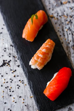 Nigiri suşi seti, yakın plan. Taze somon, beyaz balık ve pirinç üzerine karides.