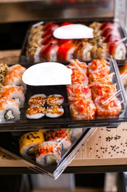 Japon yemekleri plastik kutuda yuvarlanıyor. Sushi plastik bir paketin içinde, yakın plan. Paket veya suşi servisi için suşi..