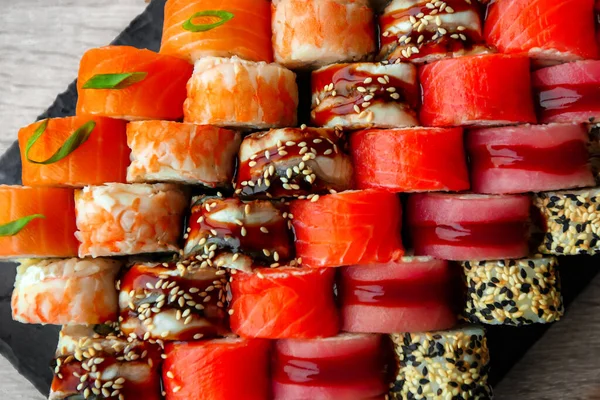 Różne japońskie bułki sushi na czarnym tle. — Zdjęcie stockowe