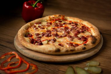 Lezzetli İtalyan pizzası ahşap masa üstü manzarasında servis edilir..