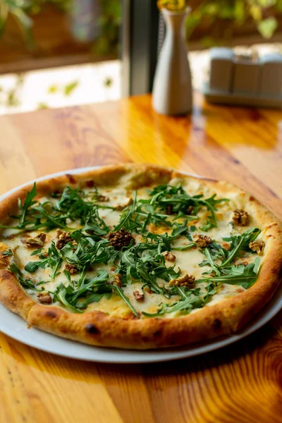 Delicious vegeterian cheese pizza with walnuts and basil wooden table background — ストック写真