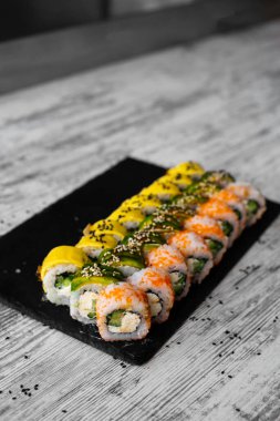 Suşi, nigiri ve suşi siyah taş levha levha üst görünümü üzerinde rulo
