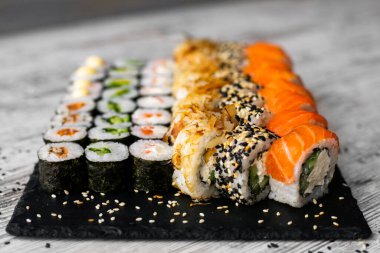 Suşi, nigiri ve suşi siyah taş levha levha üst görünümü üzerinde rulo