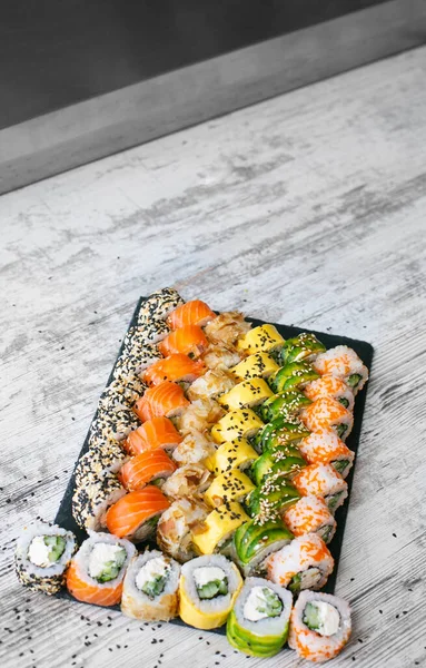 Sushi Set Nigiri und Sushi-Rollen auf schwarzem Schieferteller von oben — Stockfoto
