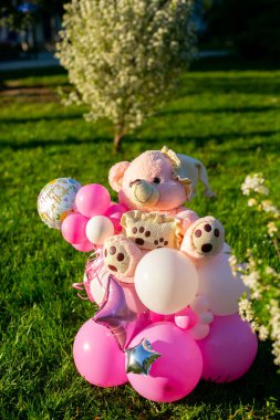 Pembe balonlar ve çimlerin üzerinde ayı bileşimi yaz güneşli