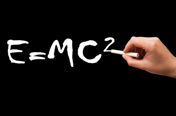 Right Hand writing on a blackboard in white, mass-energy eguivalence — Stock Photo, Image