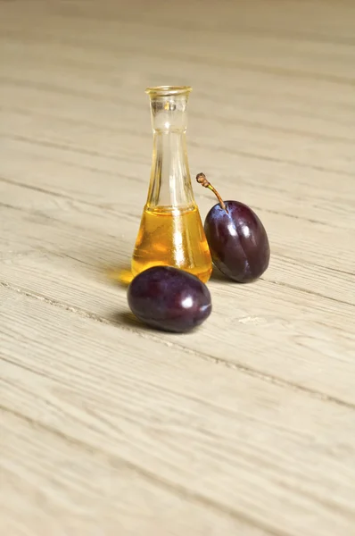 Plum brandy over a wooden background — Stock Photo, Image