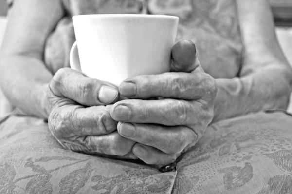 Senior hand hold a cup of tea — Stock Photo, Image