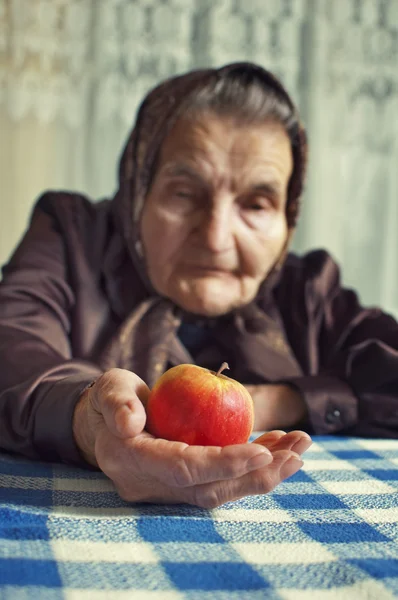 Oude vrouw met een appel. — Stockfoto