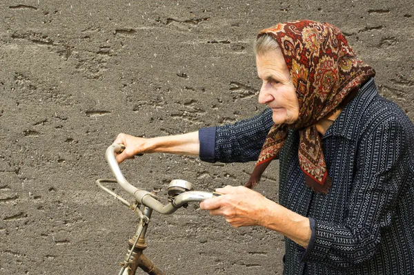 Elderly woman with bike — Stock Photo, Image