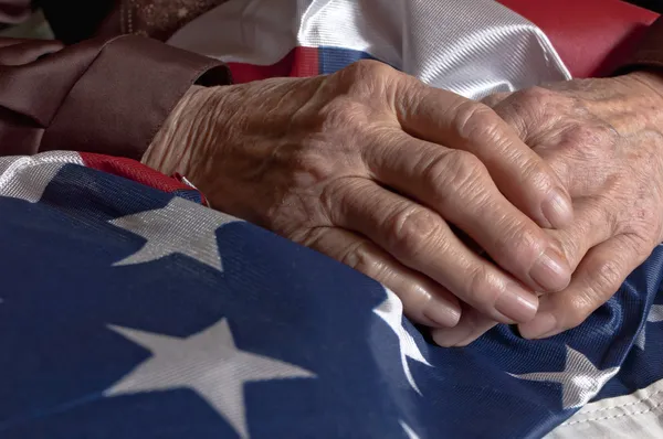 Az amerikai zászlót tartó kezek Stock Fotó