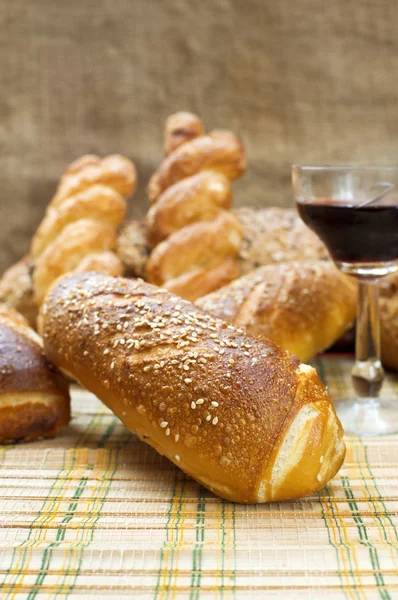 Still life assortment of bread with a glass of red wine. — Stock Photo, Image