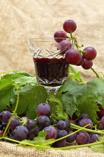 Red wine in wine glass with sweet grapes. — Stock Photo, Image