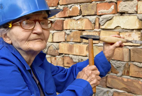 Oudere vrouw met een hamer en beitel. — Stockfoto