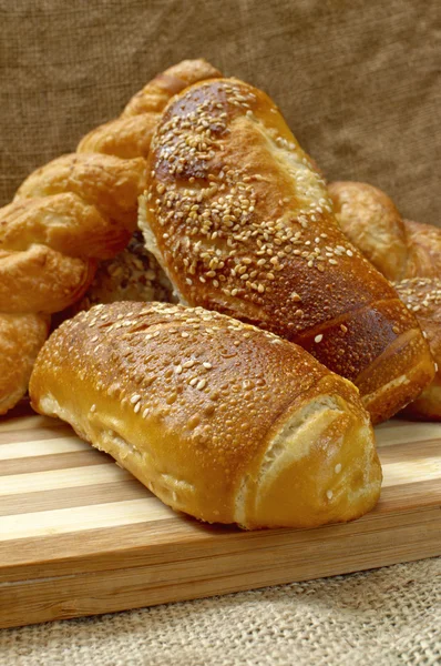 Fresh crunchy and warm home made bread on a wooden plate. — Stock Photo, Image