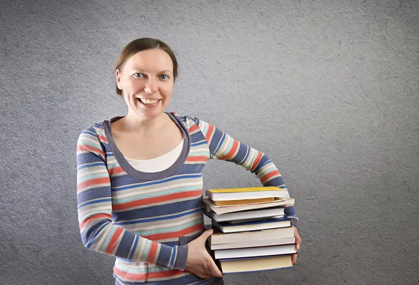 Estudiante sosteniendo pila de libros . —  Fotos de Stock