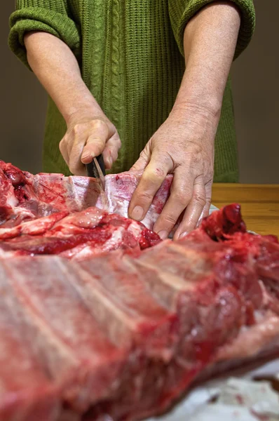 Hände schneiden Schweinefleisch. — Stockfoto