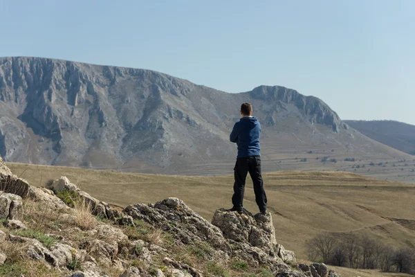 Человек стоит на вершине горы — стоковое фото