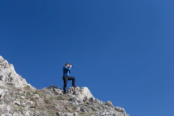 Fotografo dilettante con macchina fotografica digitale in cima alla montagna . — Foto Stock