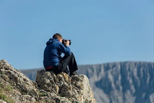 Photographe amateur avec appareil photo numérique au sommet de la montagne . — Photo