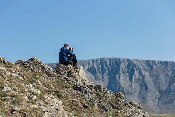 Photographe amateur avec appareil photo numérique au sommet de la montagne . — Photo