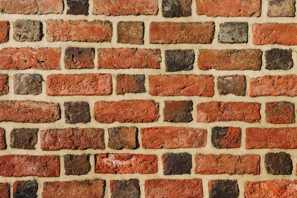 Textured red brick wall background or backdrop, rectangular red terracotta bricks laid out as pattern, architectural structure for old rough building