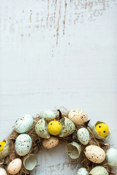 Függőleges húsvéti háttér koszorú húsvéti tojásokkal és csirkékkel. Felülnézet másolási hellyel. — Stock Fotó