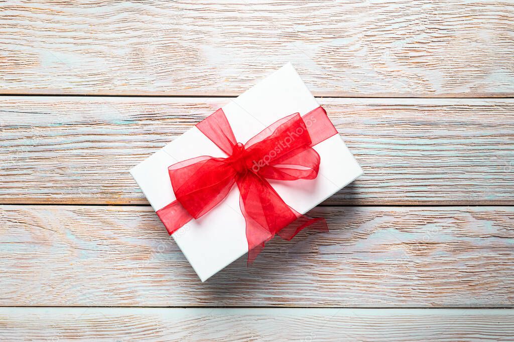 Beautiful Christmas gift box, present with red ribbon. Happy surprise.Merry Christmas. Textured wooden background. Birthday present. Copy space for text, newsletter, banner or card. 