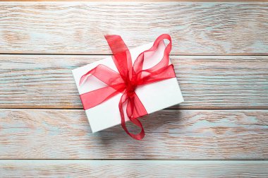 Beautiful Christmas gift box, present with red ribbon. Happy surprise.Merry Christmas. Textured wooden background. Birthday present. Copy space for text, newsletter, banner or card. 