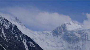 Rus dağının iki zirvesinin zamanı gökyüzünde süzülen bulutlarda Belukha