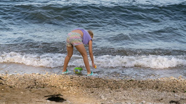 Маленькая Девочка Играет Морским Песком Фоне Морской Волны Солнечный День — стоковое фото