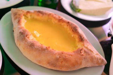 Gürcistan ulusal yemeği Adjarian Khachapuri Gürcistan 'da masada beyaz bir tabakta.