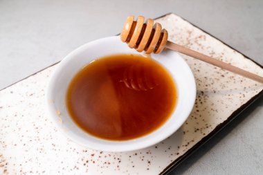 Beyaz seramik kasede taze siyah bal ile ahşap bal kaşığı