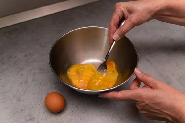 Perempuan Cambuk Telur Ayam Dengan Garpu Dalam Mangkuk Omelet Logam — Stok Foto