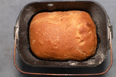 Masadaki ekmek makinesinin alüminyum kasesinde taze ekmek.