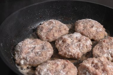 Kızartma tavasında pirzola pişirmek. Beyaz buhar tavada sıcak pirzolaların üzerinde süzülüyor.