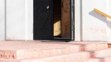 Sarı bir duvardaki güneş ışığı. Aralıklı eski kapıların karanlık bir açıklığında.