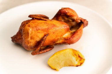 Seramik tabakta elmalı fırında bıldırcın. Lezzetli diyet yemekleri