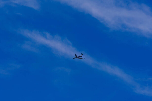 Dark jet plane in blue sky on a sunny day
