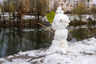 Bulutlu bir kış gününde göldeki parkta kardan adam.