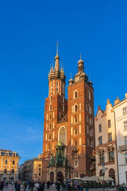 KRAKOW, POLAND - 27 Mart 2022: günbatımında Krakow 'un ana pazar meydanında Aziz Mary Bazilikası. Dikey Yönlendirme