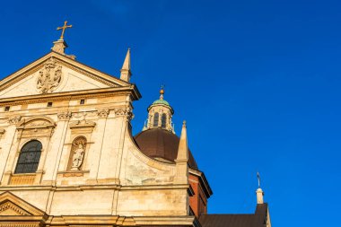 Aziz Kilisesi 'nin bir parçası. Peter ve Paul Krakow' da. Gün batımında, akşam güneşinin ışınlarında ilkbaharda mavi gökyüzüne karşı.